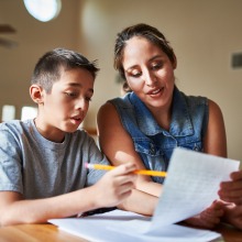 A boy doing homework with his mother