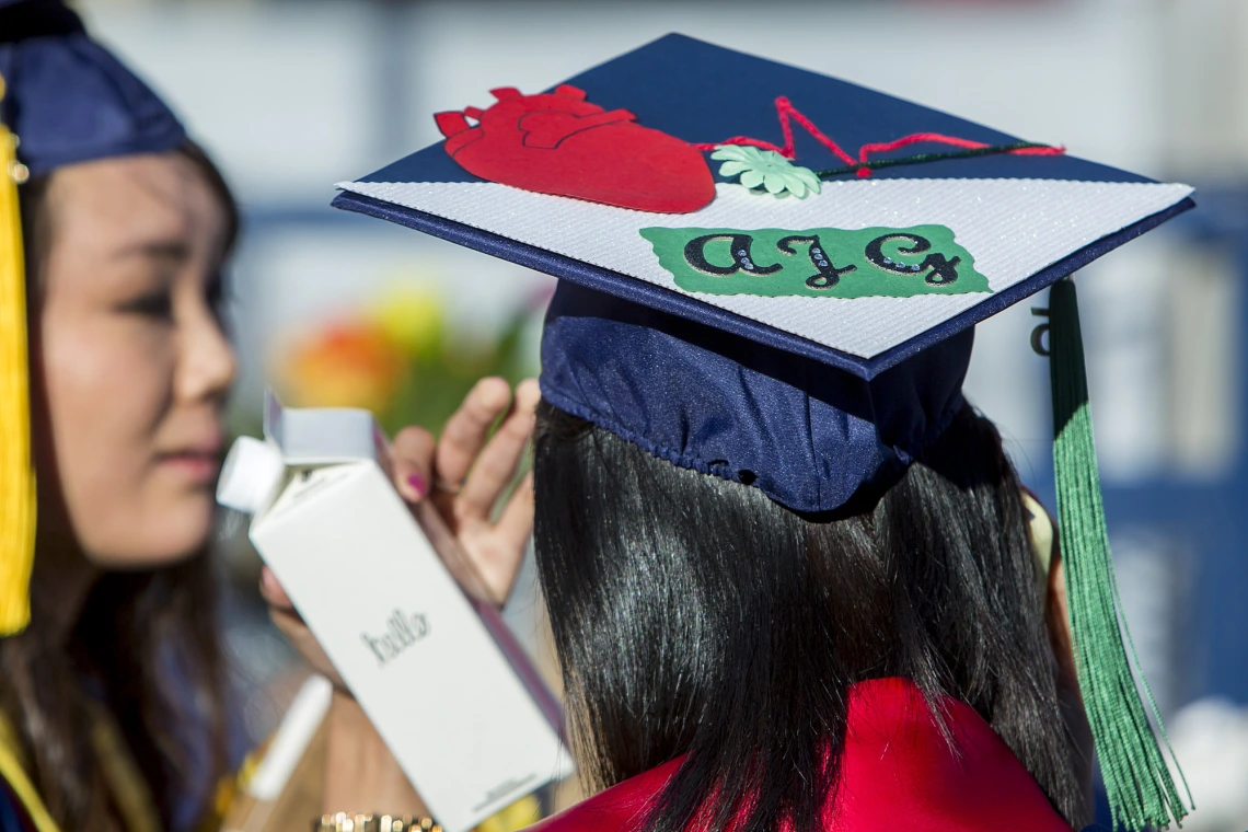 Back of a graduate's mortarboard cap with customized artwork of a heart and lettering
