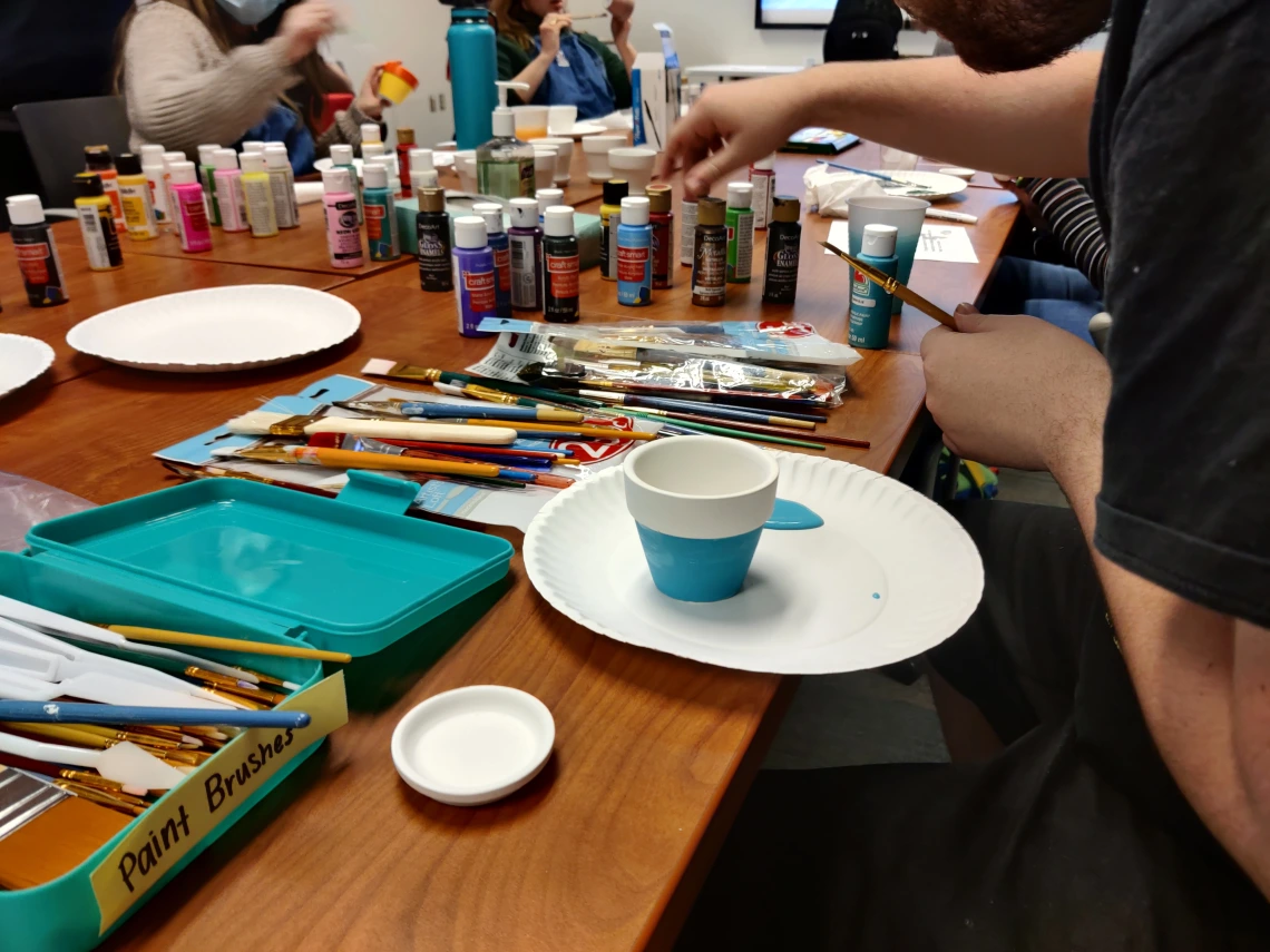 Paint, brushes, and a painted flower pot