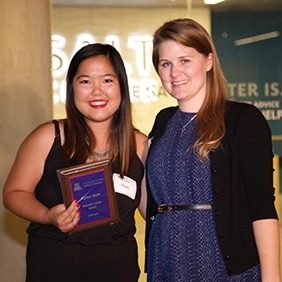 Two women posing for photo with an award.