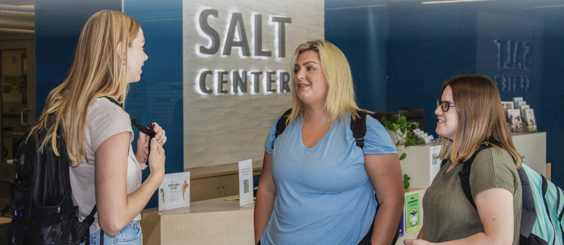 3 students standing in the SALT Center lobby