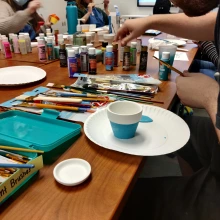 Paint, brushes, and a painted flower pot