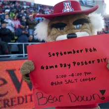 Photo of Wilber Wildcat holding a sign for this event